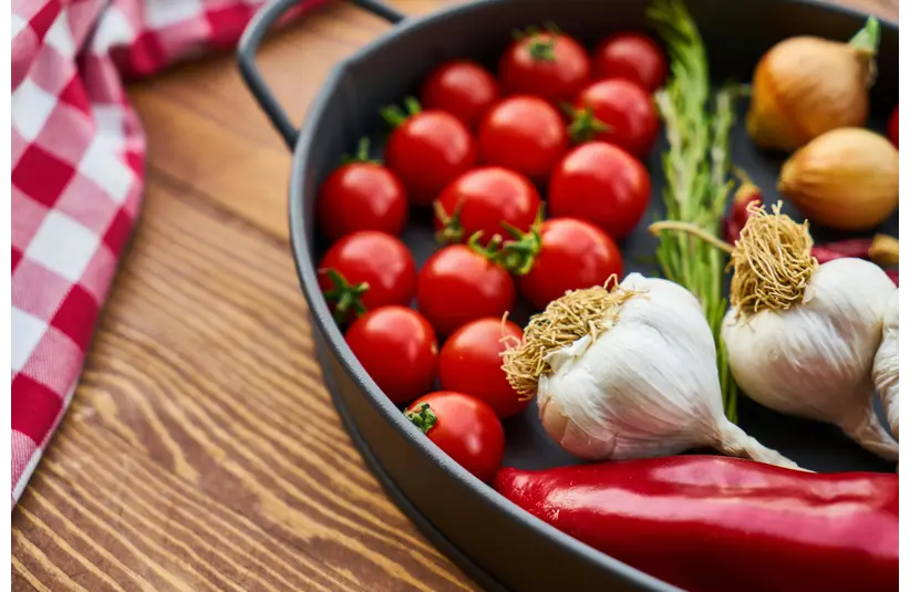 seed starting: A vivid display of fresh Mediterranean vegetables on a wooden table with a pan.