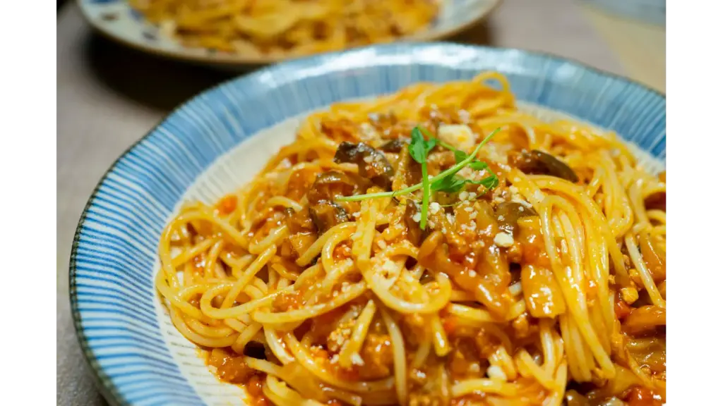 “Close‑up of a delicious spaghetti dish in tomato sauce with mushrooms and herbs, served in Tokyo, giving major pantry meals inspiration.”