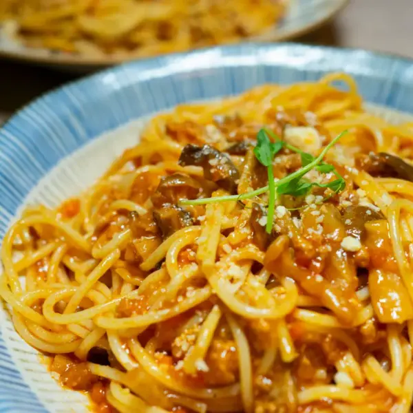 “Close‑up of a delicious spaghetti dish in tomato sauce with mushrooms and herbs, served in Tokyo, giving major pantry meals inspiration.”
