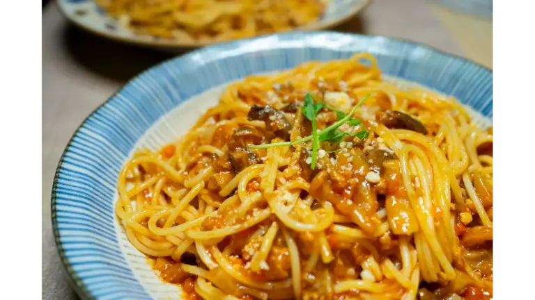 “Close‑up of a delicious spaghetti dish in tomato sauce with mushrooms and herbs, served in Tokyo, giving major pantry meals inspiration.”