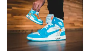Bright blue sneakers with a smaller replica, showing trendy sneaker design indoors, highlighting modern style and strong jordan value for today’s collectors.