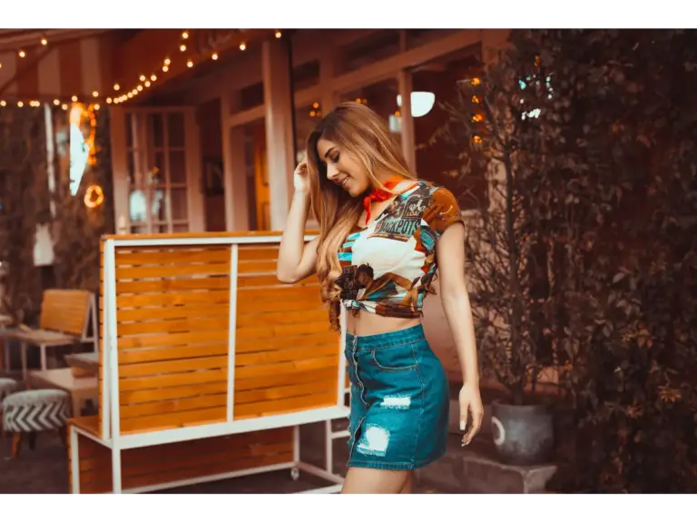 Young woman posing outdoors in casual fashion, wearing a denim skirt styled with effortless summer denim vibes.