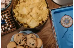 Vibrant snacking trends assortment with chips and cookies on a wooden table