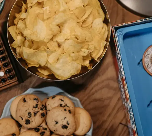 Vibrant snacking trends assortment with chips and cookies on a wooden table