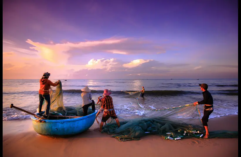 In daily devotional, fishermen are seen catching fish by the shore with a large net.