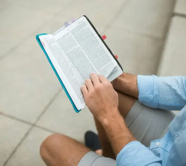 In the daily devotional, a man sits and reads the Bible.