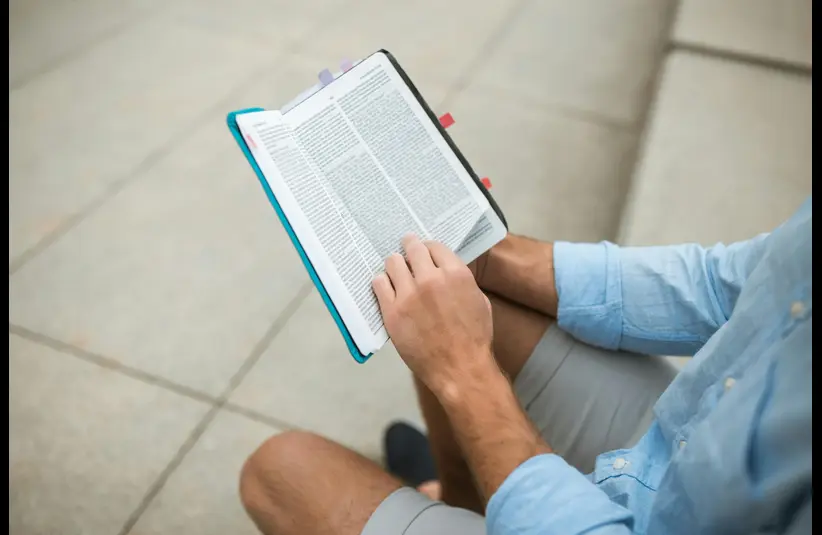 In the daily devotional, a man sits and reads the Bible.
