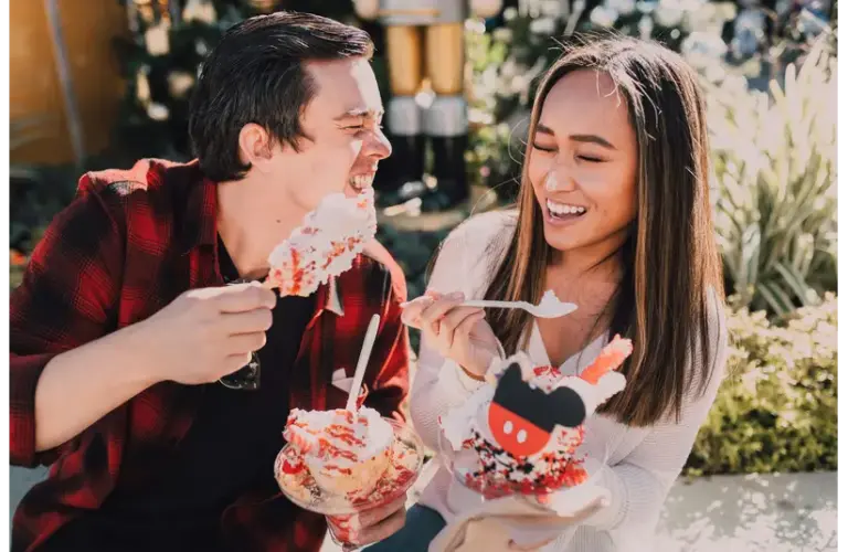 Smiling couple enjoying festive desserts outdoors during cozy dessert dates, sharing a joyful and relaxed moment together.