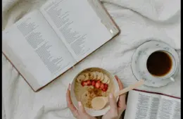 In daily devotional, someone has morning Bible study with coffee and cereal.
