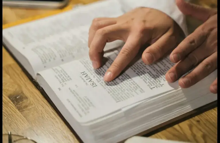 In daily devotional, a man is reading the Bible using his fingers to follow along.