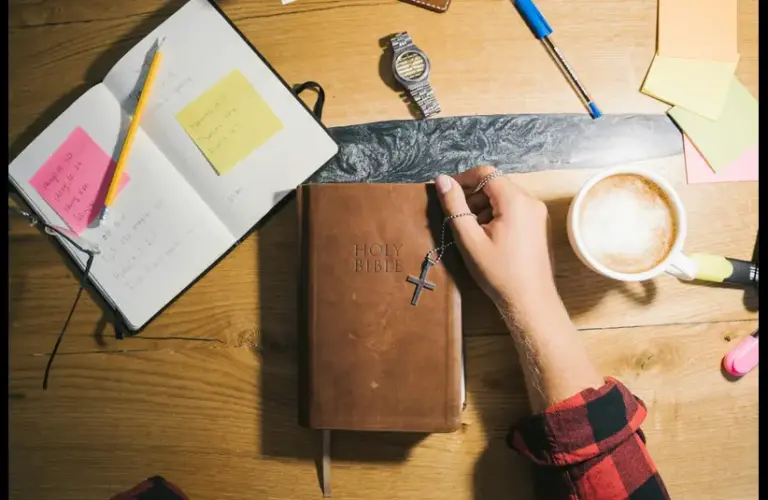 In the daily devotional, a person gets ready to do Bible study with Bible and notebook on table.
