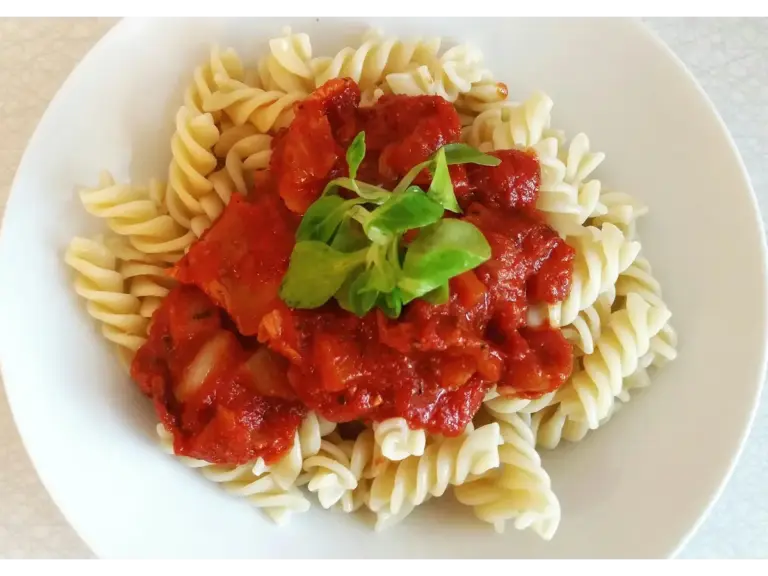 Spirelli pasta topped with rich tomato sauce and fresh greens for a perfect meal, inspired by simple and satisfying pantry meals.”