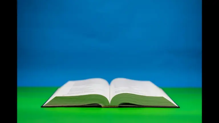 In daily devotional, an open Bible in seen with a colorful background of blue and green.