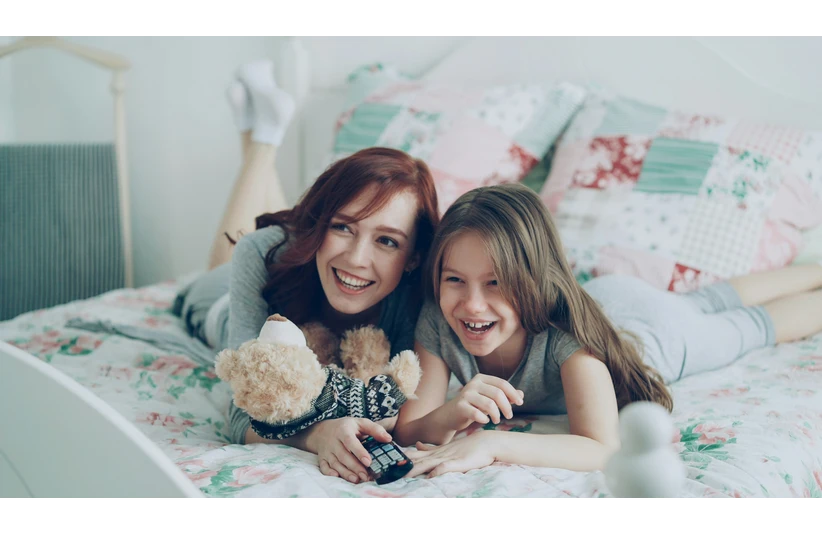 A mom and daughter spend time watching movies.