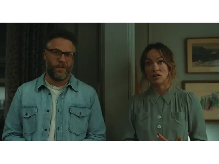 A bearded man with glasses stands beside a woman who appears worried; both have serious expressions, in the Invite.