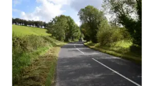 A quiet rural mystery road at Magnetic Hill in Cullion gently slopes through open countryside, creating the eerie optical illusion of cars rolling uphill.