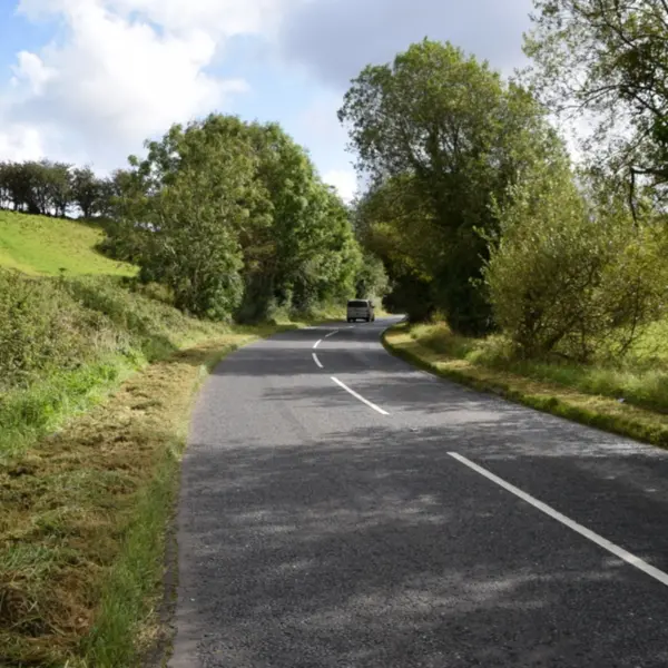 A quiet rural mystery road at Magnetic Hill in Cullion gently slopes through open countryside, creating the eerie optical illusion of cars rolling uphill.