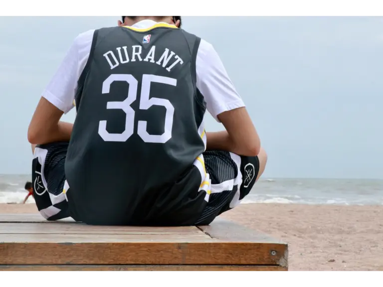 adult wearing basketball streetwear in Durant’s jersey and sitting on the beach in Qingdao