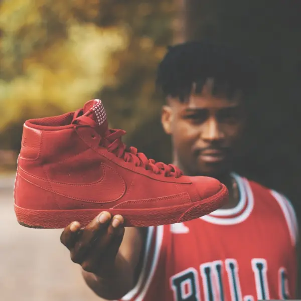adult in basketball streetwear, holding Air Jordan shoes