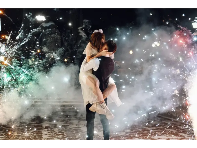 A loving couple shares a kiss as fireworks burst around them, capturing the kind of romantic moment couples travel is all about.
