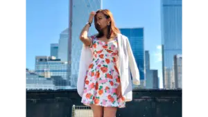 A fashionably dressed woman in a floral dress poses against a London city backdrop, highlighting the timeless appeal of floral dresses.