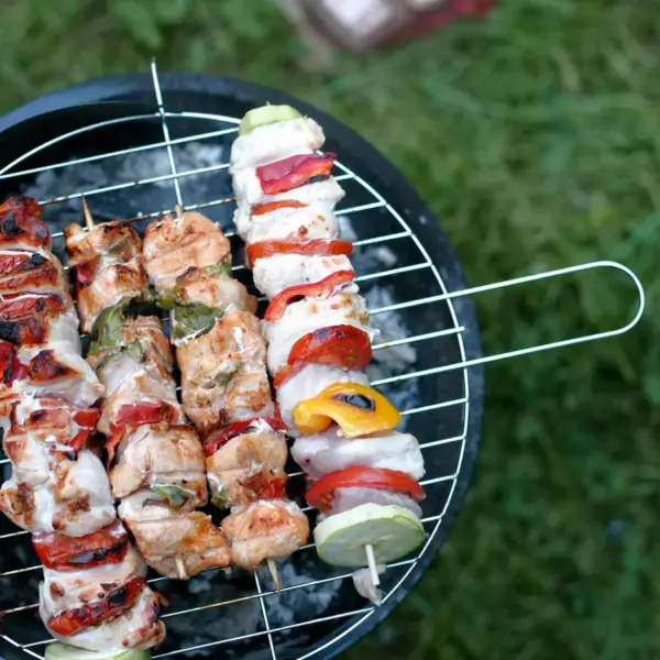Close-up view of colorful chicken skewers on a charcoal grill