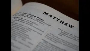 In dailyl devotional, a Bible is open to Matthew.