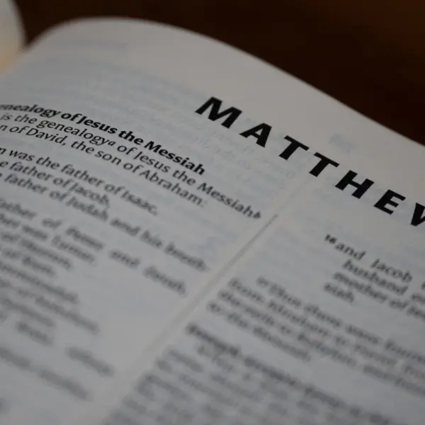 In dailyl devotional, a Bible is open to Matthew.