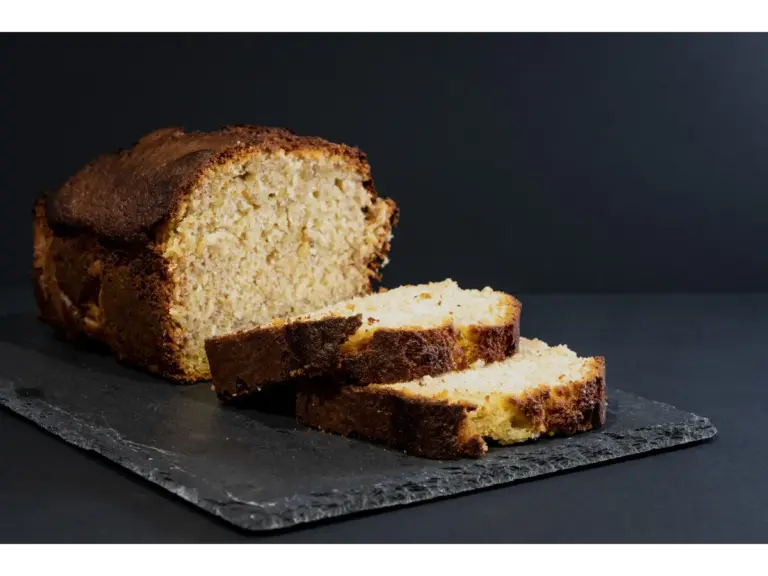 Tasty banana bread loaf with slices on a slate board, perfect for dessert or snack
