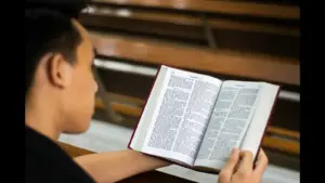 In daily devotional, a young man reads the Bible.