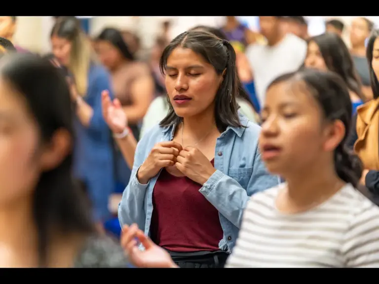 In daily devotional, a group of people are praying and praising God.