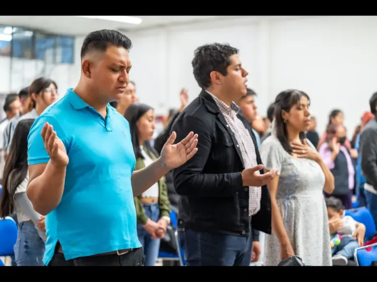 In daily devotional, people are praying and singing praises in a church setting.
