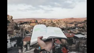 In daily devotional, an open Bible is held out over the city of Jerusalem.
