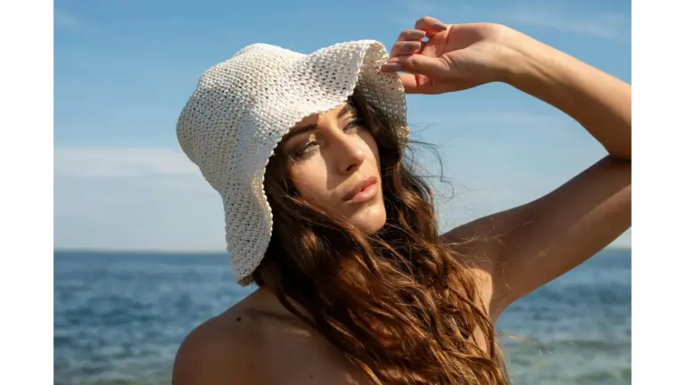Crochet hats capture the same soft, breezy vibe as a woman wearing a sun hat while she enjoys a sunny day at the seaside in Tallinn, Estonia.