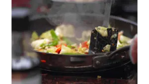 a vibrant stir fry of fresh vegetables sizzling in a pan, releasing steam and capturing the same bold, chaotic energy found in dirty cabbage dishes.