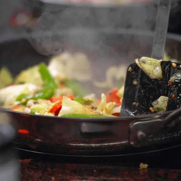 a vibrant stir fry of fresh vegetables sizzling in a pan, releasing steam and capturing the same bold, chaotic energy found in dirty cabbage dishes.