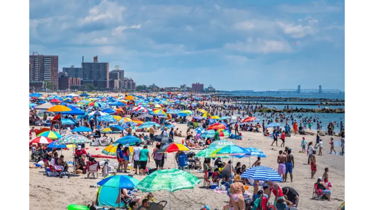 travel chaos unfolds at Coney Island as a vibrant summer scene shows beachgoers, umbrellas, and the shoreline packed with energy.