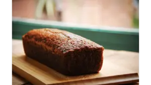 Delicious homemade banana bread loaf placed on a wooden cutting board, perfect for breakfast or a sweet snack.