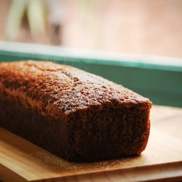 Delicious homemade banana bread loaf placed on a wooden cutting board, perfect for breakfast or a sweet snack.