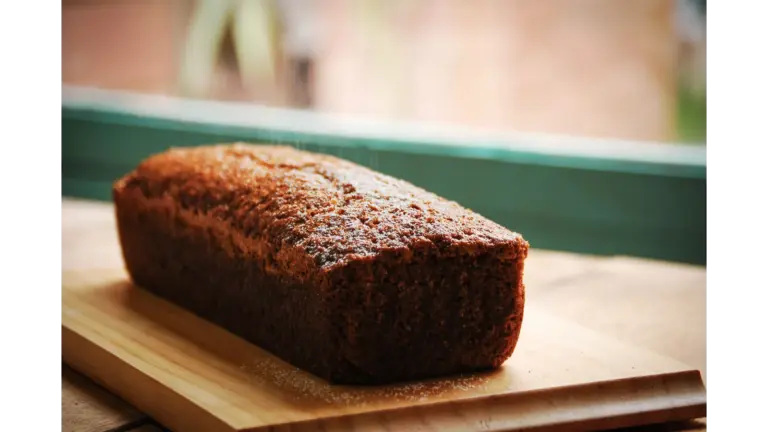 Delicious homemade banana bread loaf placed on a wooden cutting board, perfect for breakfast or a sweet snack.