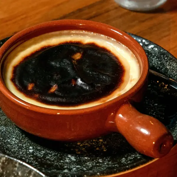 Recipe fails show up fast when you’re staring at a close‑up of a rich burnt Basque cheesecake served in a traditional ceramic dish on a wooden table.
