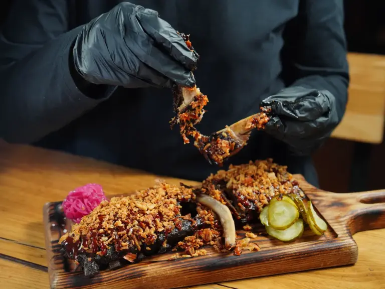 Ribs topped with crunchy crumbs, served on a wooden board, showcasing recipe fails and unexpected cooking results.