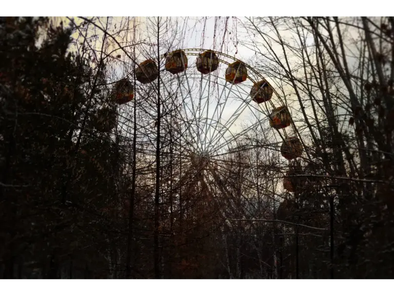 An eerie Ferris wheel rising over an overgrown twilight landscape, capturing the haunting atmosphere of abandoned parks.