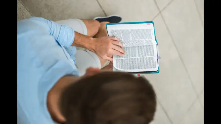 In daily devotional, a man reads the Bible alone separated from others.
