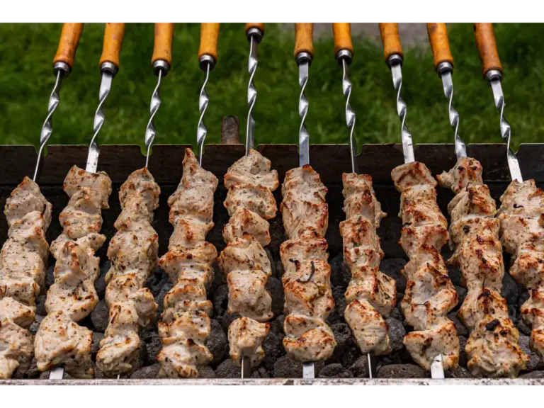 Juicy chicken skewers grilling on an outdoor charcoal barbecue, perfect for a summer cookout