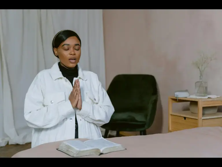 In daily devotional, a woman kneels in prayer as she talks to God.