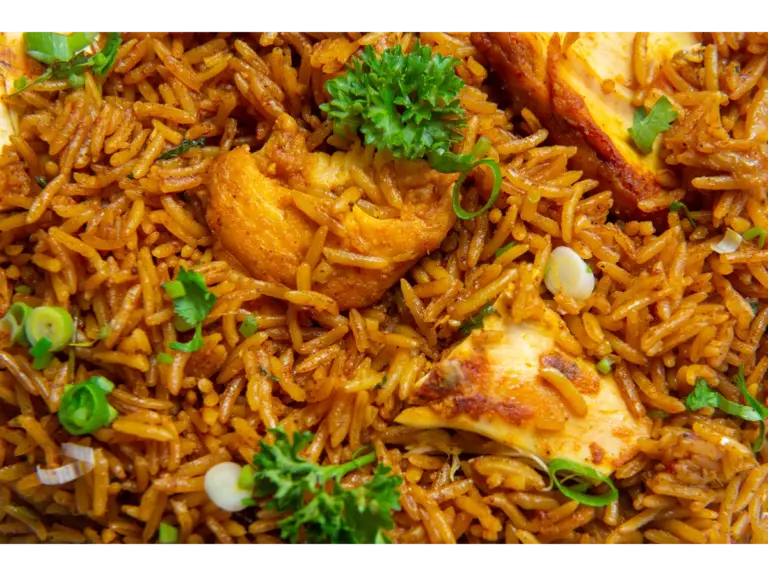 A warm plate of chicken Perlou, garnished with herbs,