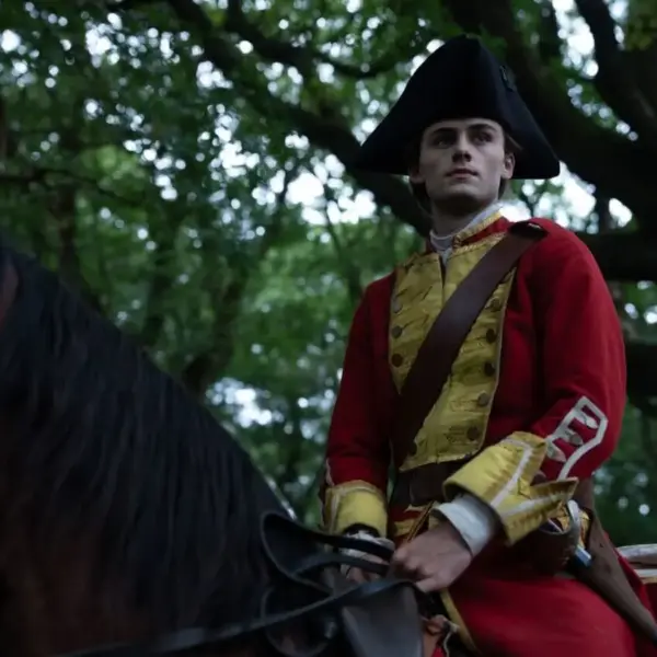 William Franklyn-Miller as Young Washington, dressed in a historical military uniform, sits on a horse amidst trees.