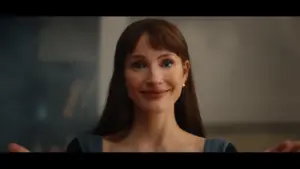 Jessica Chastain in Other Mommy (2026) with brown hair and a warm smile, wearing a blue top, appears to be expressing a welcoming or comforting emotion.