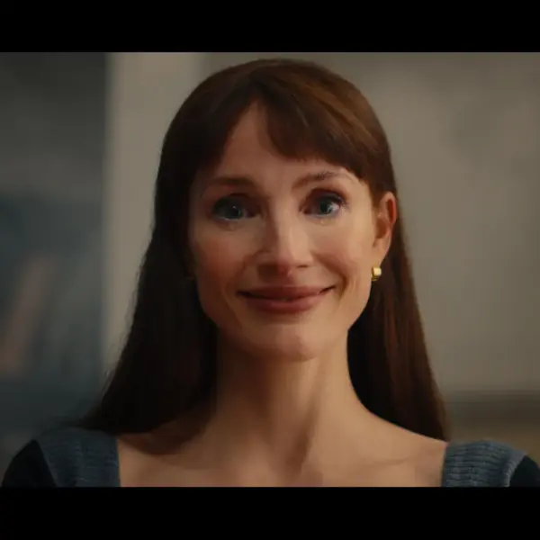 Jessica Chastain in Other Mommy (2026) with brown hair and a warm smile, wearing a blue top, appears to be expressing a welcoming or comforting emotion.